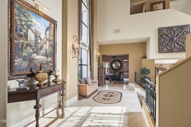 foyer entrance with a towering ceiling and a notable chandelier