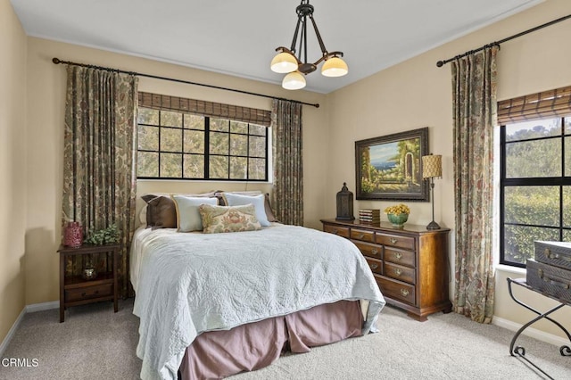 carpeted bedroom featuring a notable chandelier