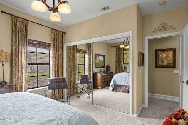 bedroom featuring light carpet, a closet, and ceiling fan with notable chandelier