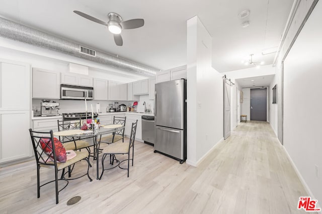 kitchen featuring ceiling fan, sink, light hardwood / wood-style flooring, and stainless steel appliances