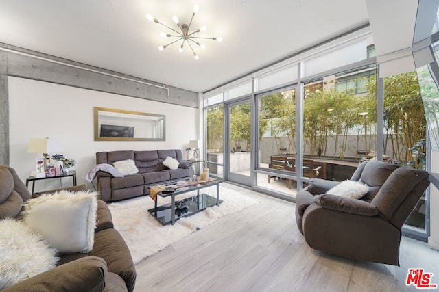 living room with floor to ceiling windows, a chandelier, and light wood-type flooring