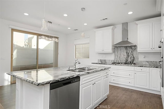 kitchen with wall chimney range hood, white cabinetry, appliances with stainless steel finishes, and sink