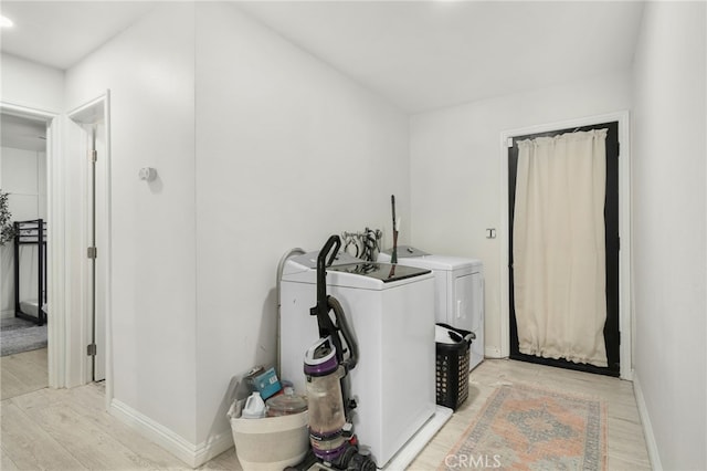 laundry area featuring washer and clothes dryer and light wood-type flooring