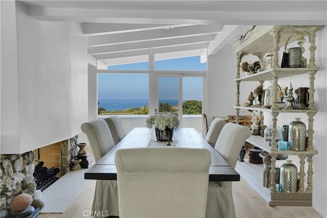 dining space featuring light hardwood / wood-style flooring and lofted ceiling with beams