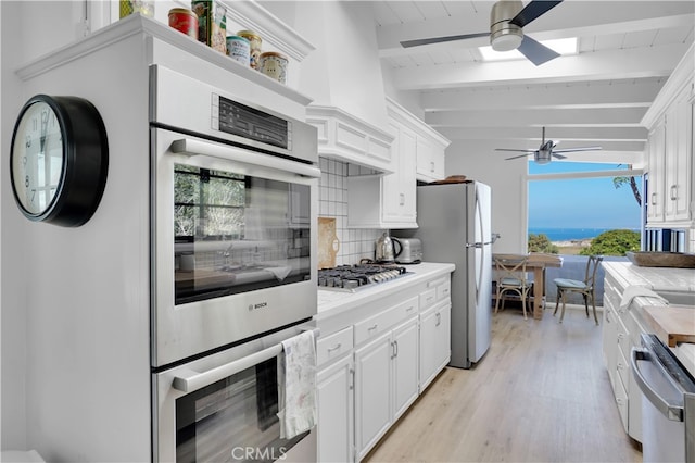 kitchen featuring white cabinetry, tasteful backsplash, and beamed ceiling