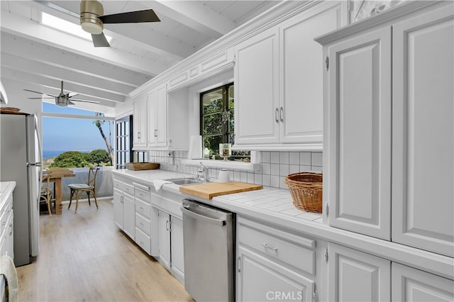 kitchen featuring backsplash, white cabinetry, and appliances with stainless steel finishes