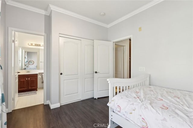 bedroom with connected bathroom, dark hardwood / wood-style floors, a closet, and ornamental molding