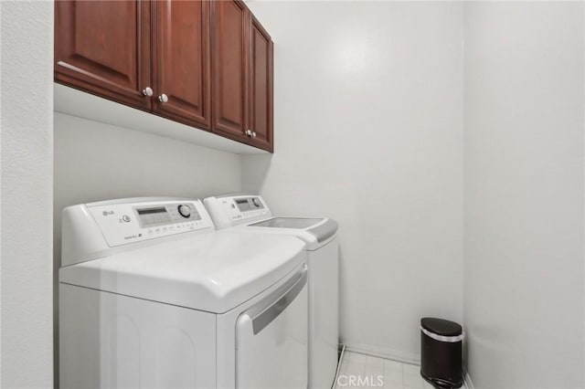 laundry area featuring washer and dryer and cabinets