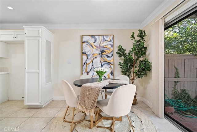 dining area featuring crown molding, baseboards, and light tile patterned floors