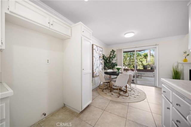 dining area with light tile patterned floors and crown molding