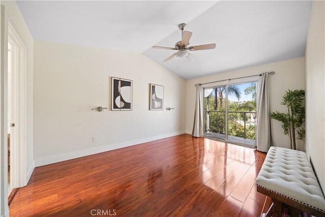 spare room with a ceiling fan, baseboards, vaulted ceiling, and wood finished floors