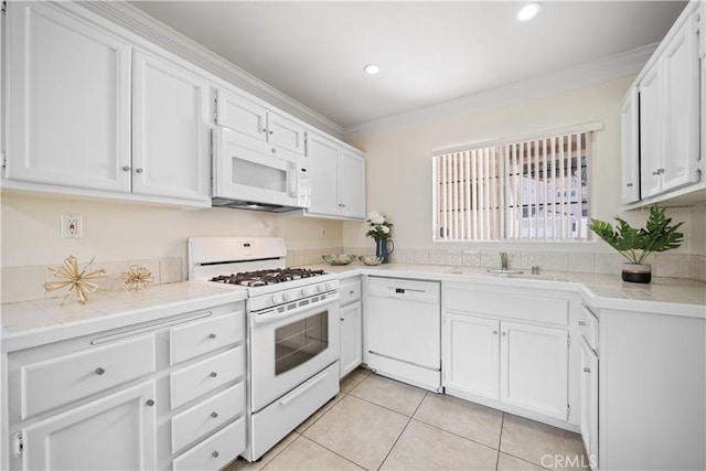 kitchen featuring ornamental molding, white appliances, white cabinets, and a sink