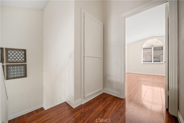 hall with dark wood-style floors and baseboards