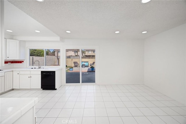 kitchen featuring a textured ceiling, white cabinets, dishwasher, sink, and tile countertops