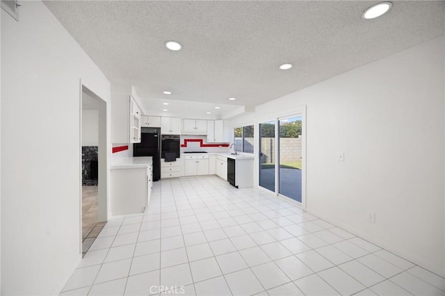 kitchen with light tile patterned floors, white cabinetry, a textured ceiling, black appliances, and sink