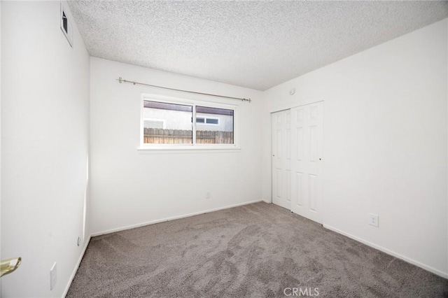 spare room with a textured ceiling and carpet flooring