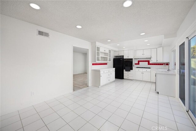 kitchen with decorative backsplash, a textured ceiling, black appliances, white cabinets, and sink