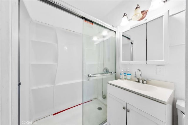 bathroom featuring an enclosed shower, vanity, and toilet