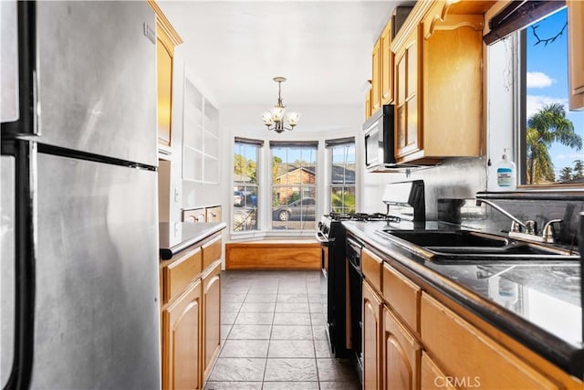 kitchen with decorative light fixtures, sink, appliances with stainless steel finishes, light tile patterned floors, and a chandelier