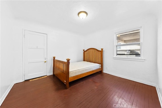 bedroom with dark wood-type flooring