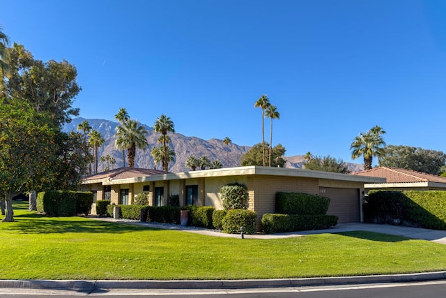 ranch-style house featuring a front yard, a garage, and a mountain view