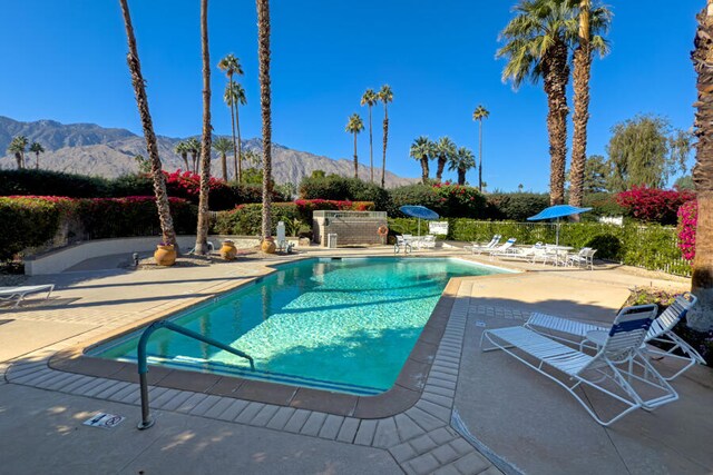 view of swimming pool featuring a mountain view and a patio