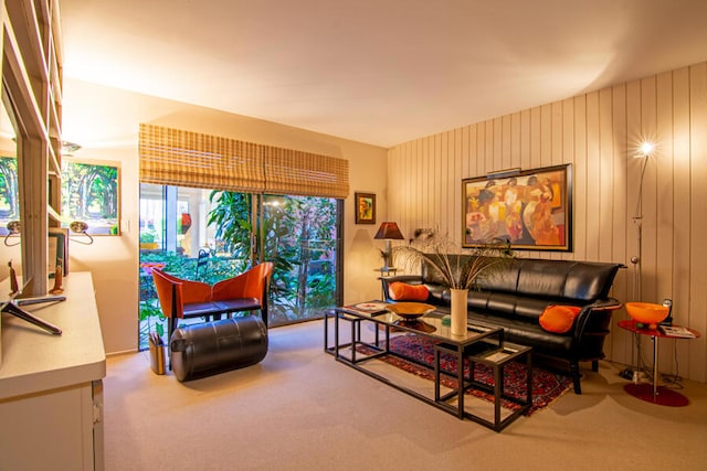 carpeted living room featuring wooden walls