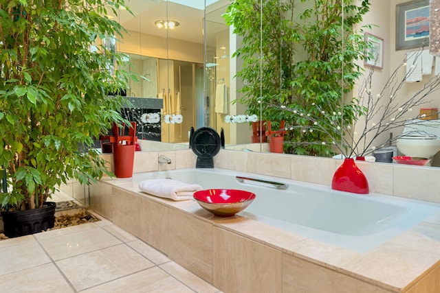 bathroom featuring tile patterned flooring and a relaxing tiled tub