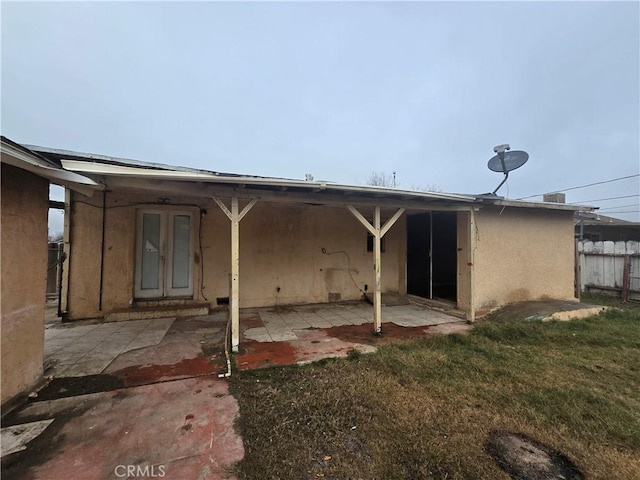 rear view of property featuring french doors, a patio area, and a yard