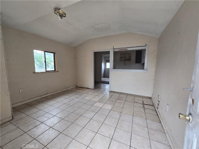 tiled empty room with lofted ceiling