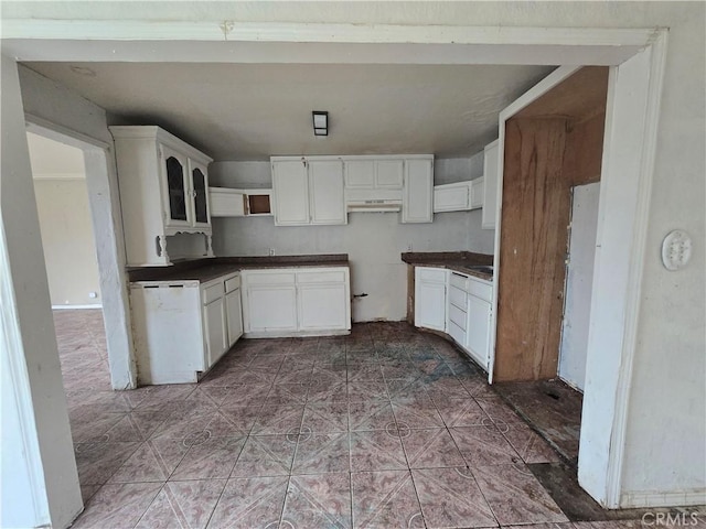 kitchen featuring white dishwasher, white cabinets, and dark tile patterned floors