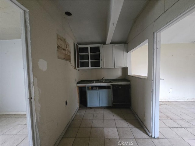 kitchen featuring light tile patterned flooring, lofted ceiling, and sink