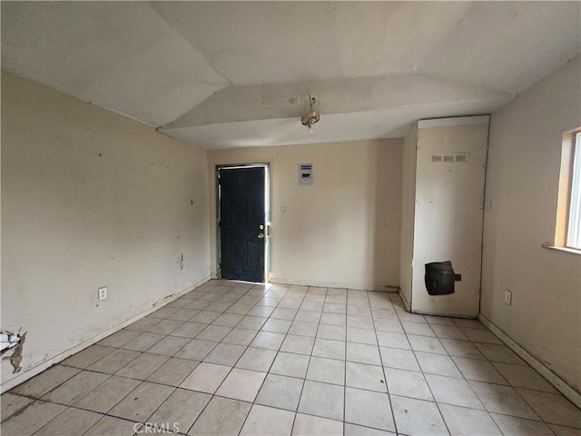 tiled empty room with vaulted ceiling