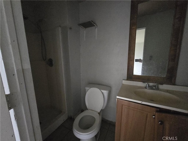 bathroom featuring tile patterned flooring, toilet, walk in shower, and vanity