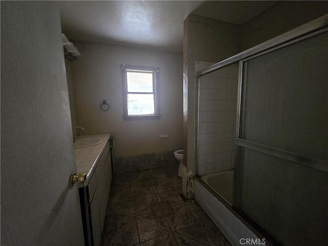 full bathroom featuring bath / shower combo with glass door, toilet, and vanity