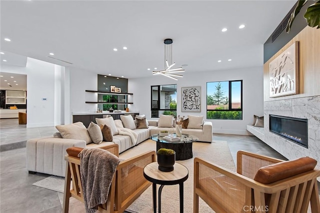 living room featuring a high end fireplace and an inviting chandelier