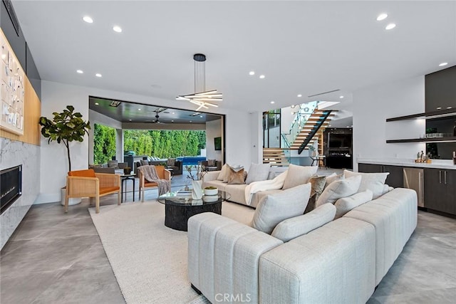 living room featuring a premium fireplace and ceiling fan