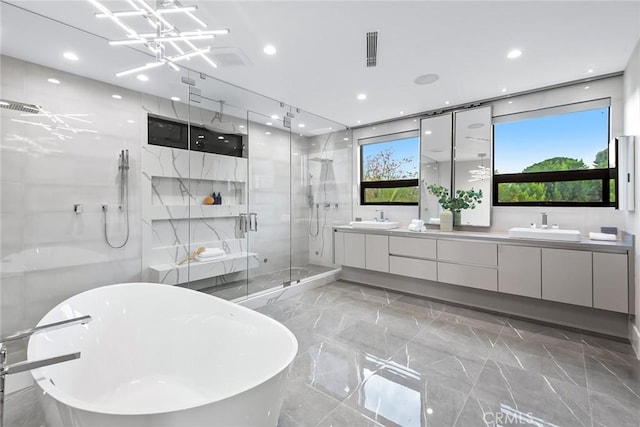 bathroom featuring separate shower and tub, vanity, and a chandelier