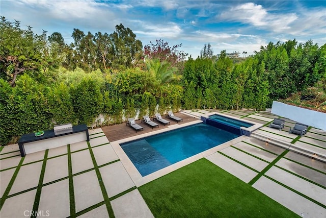 view of pool featuring an outdoor kitchen and a patio area