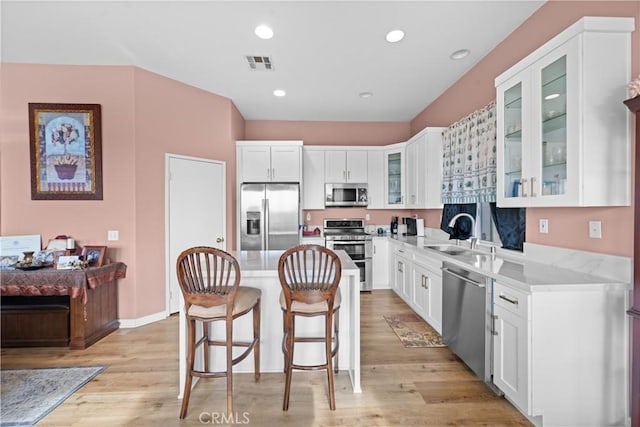 kitchen with stainless steel appliances, white cabinetry, and sink