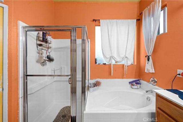 bathroom featuring vanity, independent shower and bath, and a healthy amount of sunlight