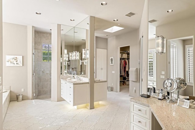 bathroom with vanity, independent shower and bath, and a chandelier