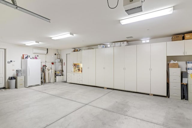 garage featuring an AC wall unit, strapped water heater, and white fridge