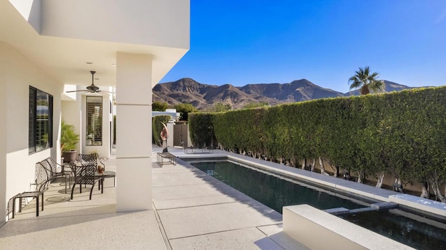 view of pool featuring ceiling fan, a mountain view, a patio, and an in ground hot tub