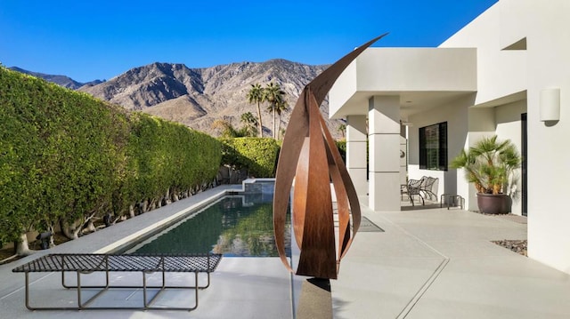 view of pool with a patio area and a mountain view