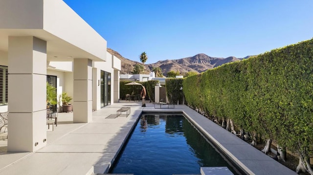 view of swimming pool with a mountain view and a patio area