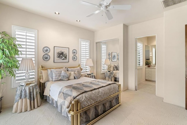 bedroom with ceiling fan, carpet, and ensuite bath