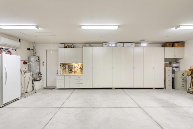 garage featuring a wall mounted AC, water heater, and white fridge