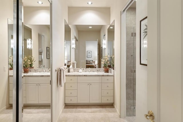 bathroom with tile patterned flooring, a shower with door, and vanity