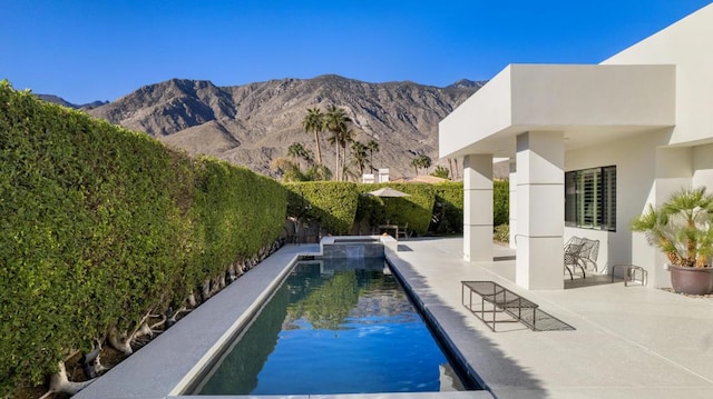 view of swimming pool featuring a patio area and a mountain view